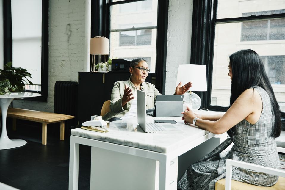 Business mentor coaching a professional during a leadership mentoring session focused on career growth, knowledge sharing, and executive development.